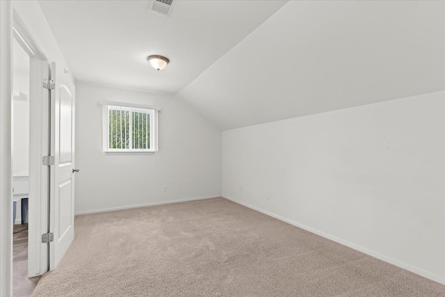 additional living space featuring vaulted ceiling, visible vents, baseboards, and carpet