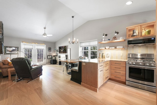 kitchen with light wood finished floors, light brown cabinets, stainless steel appliances, open floor plan, and tasteful backsplash