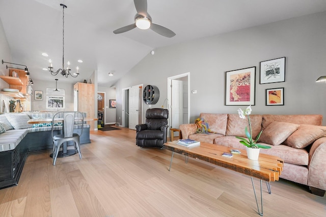 living room with light wood finished floors, lofted ceiling, and ceiling fan with notable chandelier
