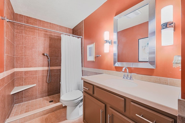 bathroom featuring vanity, toilet, and tiled shower