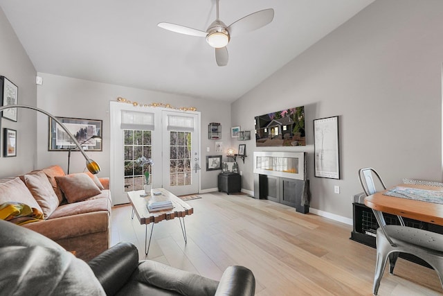 living room with light wood-type flooring, baseboards, ceiling fan, and high vaulted ceiling