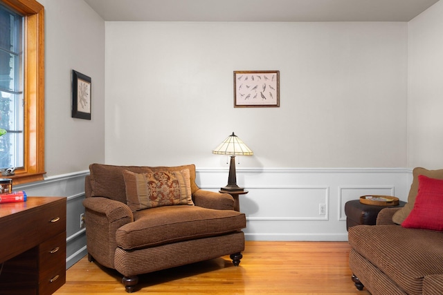 sitting room featuring light wood-style flooring and wainscoting