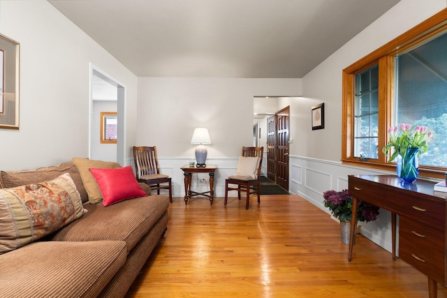 living room featuring light wood-style floors and a wainscoted wall