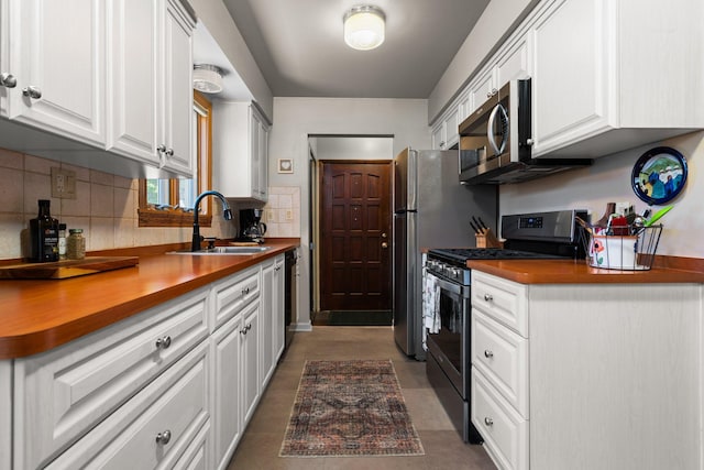 kitchen featuring a sink, appliances with stainless steel finishes, decorative backsplash, and white cabinets