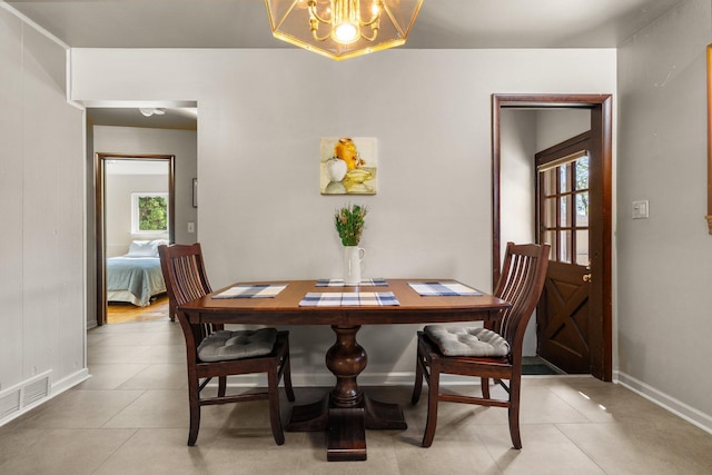 dining area featuring baseboards, an inviting chandelier, light tile patterned floors, and visible vents