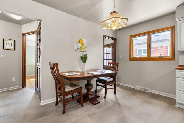 dining space with visible vents, baseboards, light tile patterned floors, and a notable chandelier