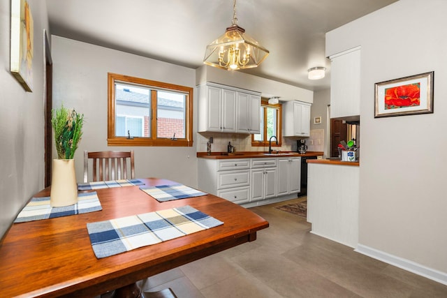 dining room featuring an inviting chandelier and baseboards