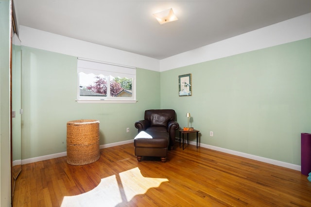 sitting room featuring baseboards and wood finished floors