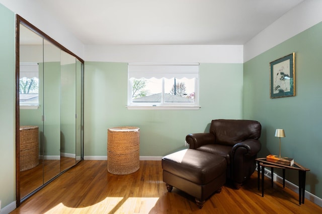 living area with plenty of natural light, baseboards, and wood finished floors