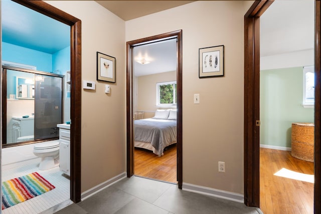 hallway with baseboards and tile patterned floors