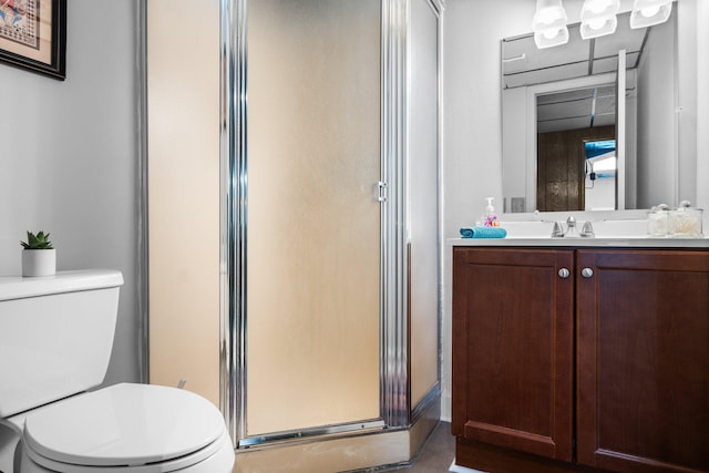 bathroom with vanity, a stall shower, and toilet