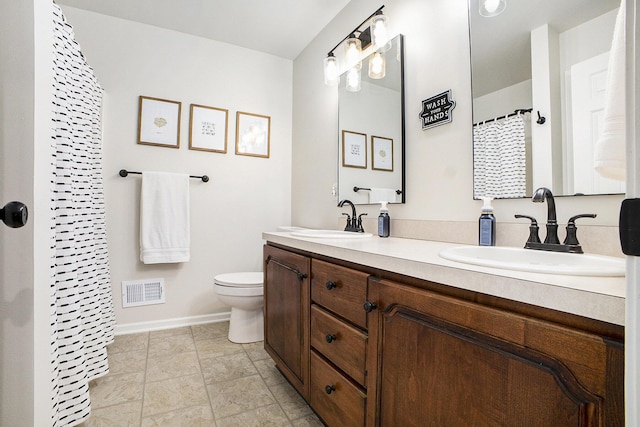 bathroom with toilet, baseboards, visible vents, and a sink