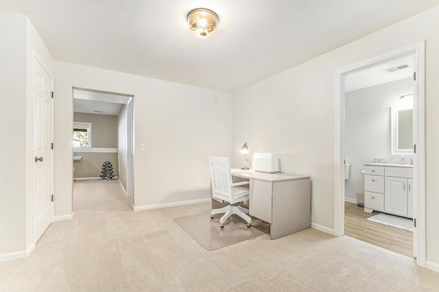 home office with visible vents, baseboards, and light colored carpet