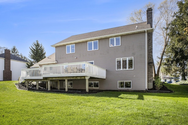back of property with a lawn, a chimney, and a wooden deck