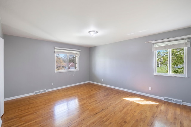 spare room with visible vents, baseboards, and light wood-type flooring