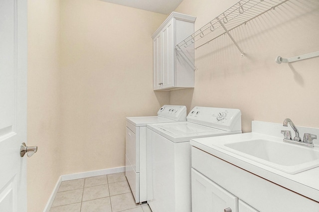 8 Georgia Ct, Pentwater, MI 49449 - clothes washing area featuring cabinet space, light tile patterned floors, baseboards, a sink, and washer and clothes dryer