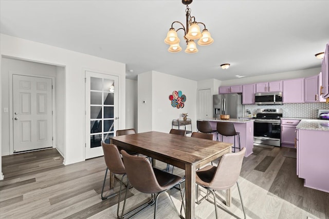 dining room featuring light wood-style floors and a chandelier