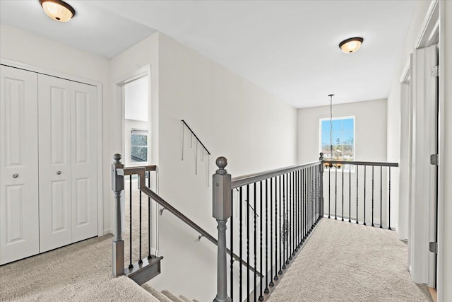 corridor featuring carpet floors and an upstairs landing
