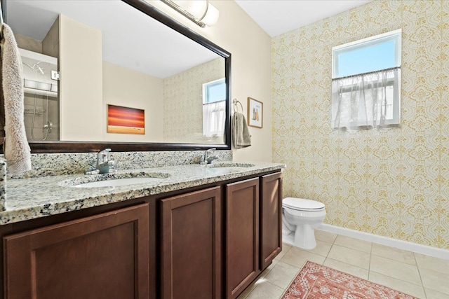 bathroom featuring toilet, plenty of natural light, and a sink