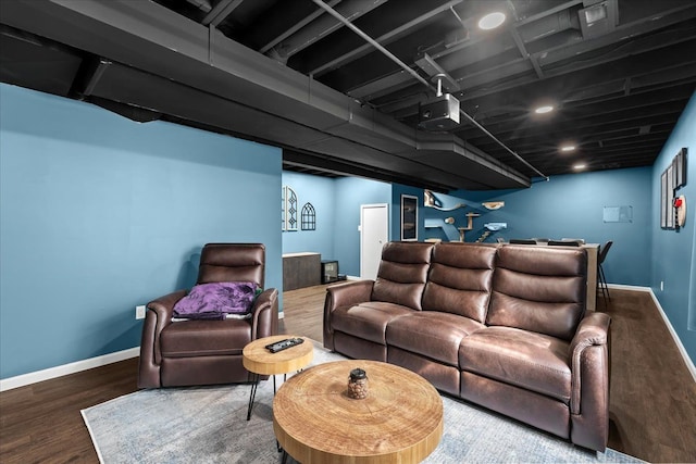 living area with baseboards, wood finished floors, and bar area