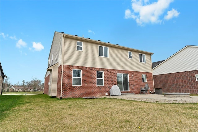 back of house with brick siding, central AC unit, a lawn, and a patio