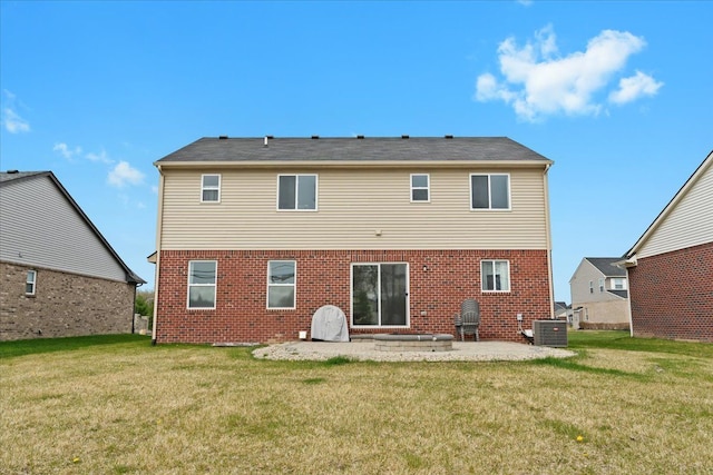 back of property with brick siding, a patio area, a yard, and cooling unit