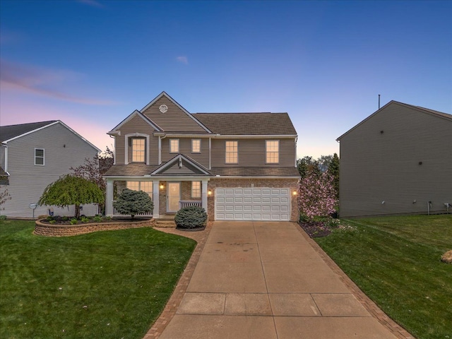 view of front of property featuring a lawn, brick siding, an attached garage, and driveway