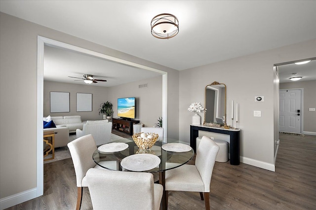 dining space with a ceiling fan, baseboards, visible vents, and wood finished floors