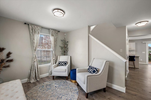 living area with baseboards, wood finished floors, a healthy amount of sunlight, and stairway