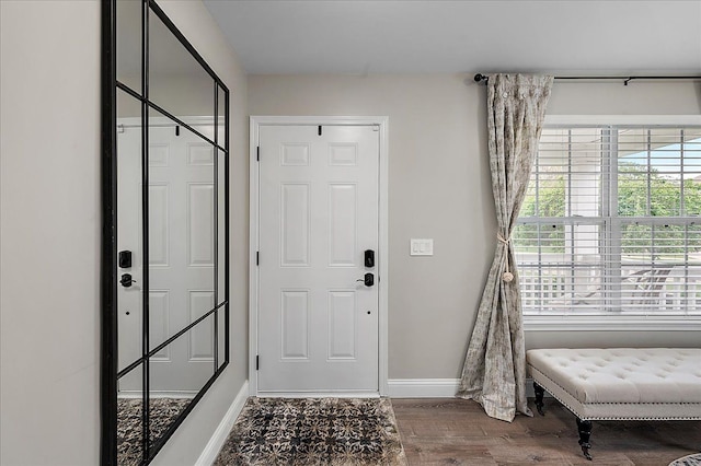 foyer featuring baseboards and wood finished floors