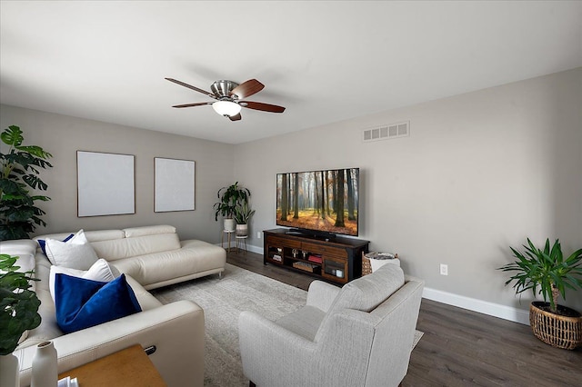 living room with baseboards, a ceiling fan, wood finished floors, and visible vents