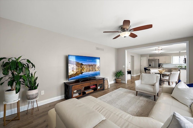 living room with visible vents, a ceiling fan, baseboards, and wood finished floors