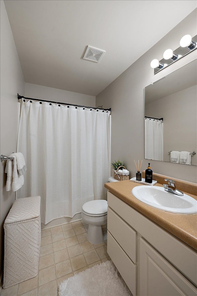 bathroom featuring toilet, visible vents, tile patterned flooring, and vanity