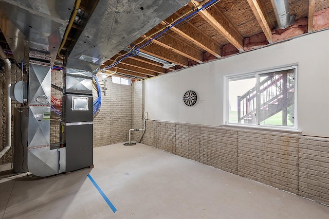 basement with brick wall and heating unit