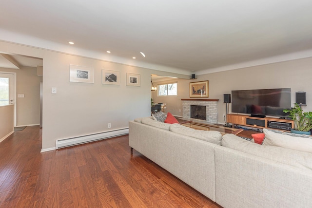 living room with baseboard heating, a fireplace, recessed lighting, baseboards, and wood finished floors