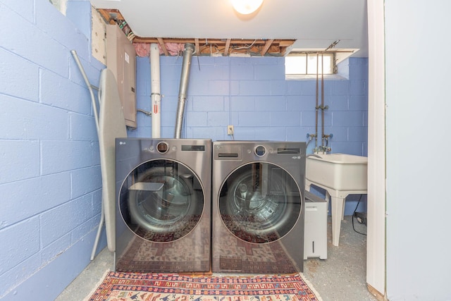 clothes washing area with laundry area, independent washer and dryer, and concrete block wall