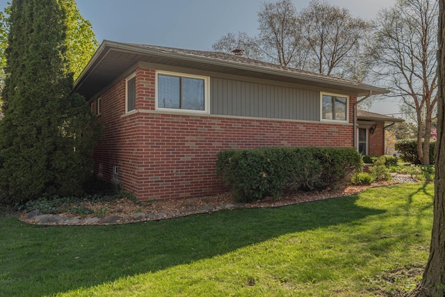view of home's exterior with a lawn and brick siding