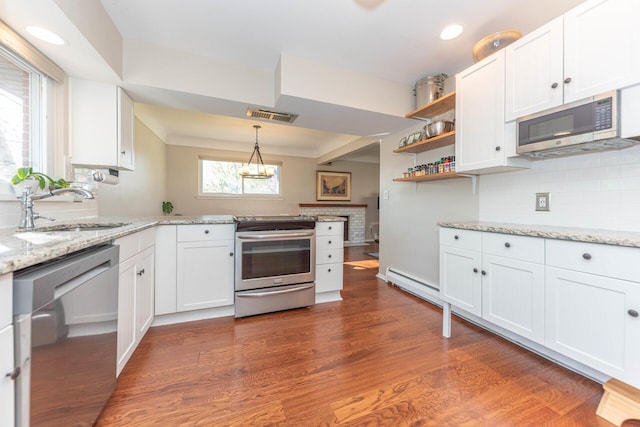kitchen featuring a sink, stainless steel appliances, white cabinetry, a peninsula, and visible vents