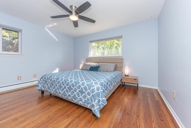 bedroom with baseboards, a ceiling fan, a baseboard radiator, and wood finished floors