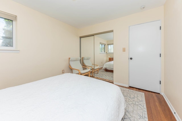 bedroom featuring baseboards, a closet, and wood finished floors