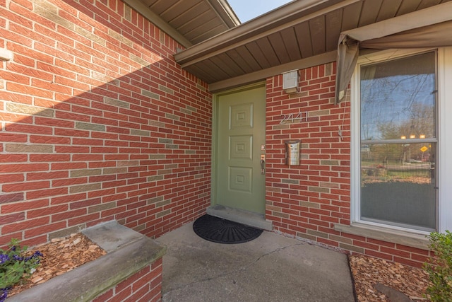 view of exterior entry with brick siding