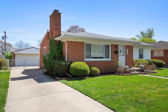 view of front facade featuring brick siding, a garage, a front yard, a chimney, and an outdoor structure