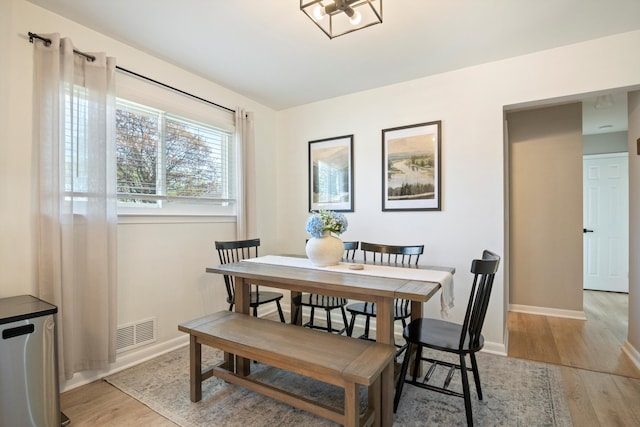 dining room featuring visible vents, light wood-style flooring, and baseboards