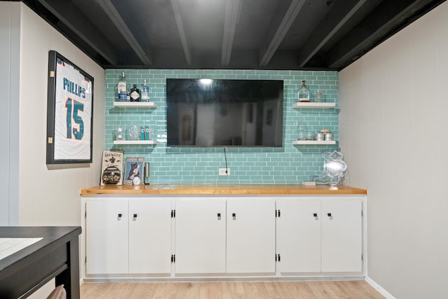 bar featuring decorative backsplash, light wood-style flooring, and beam ceiling