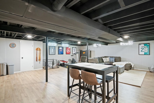 basement featuring light wood finished floors and a wealth of natural light