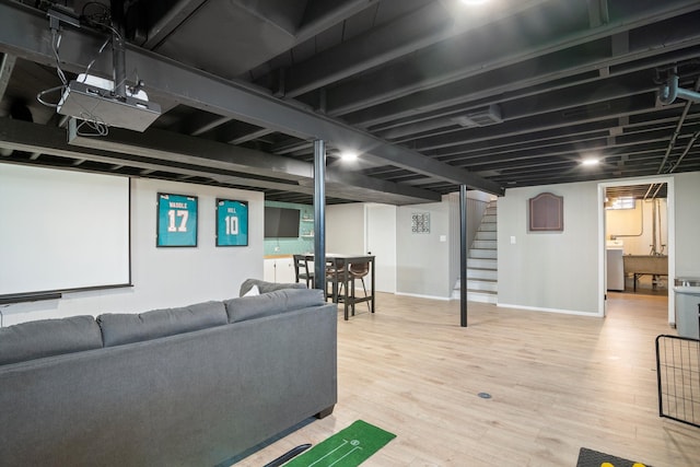 interior space with baseboards, washer / clothes dryer, stairs, and wood finished floors