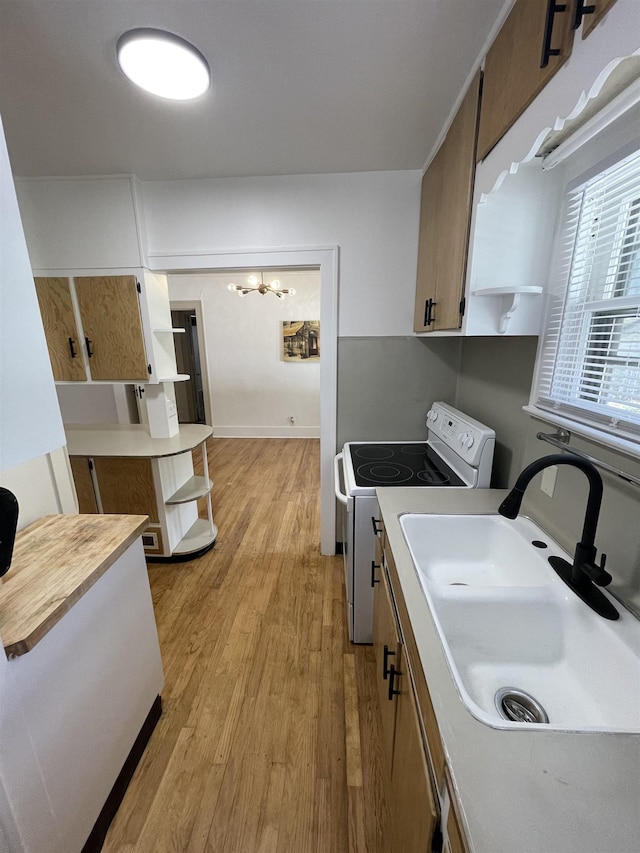 kitchen featuring a sink, open shelves, white electric stove, and light wood-type flooring
