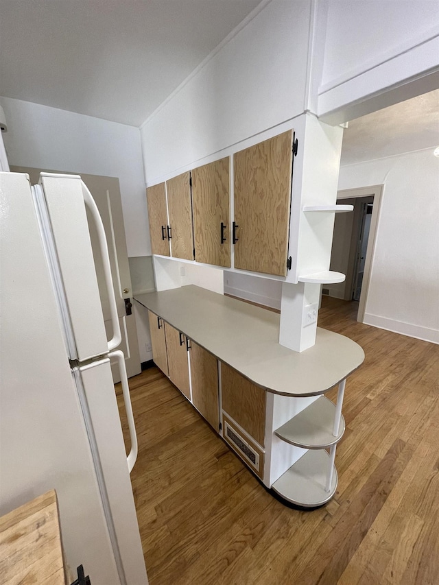 kitchen featuring light countertops, freestanding refrigerator, wood finished floors, and visible vents