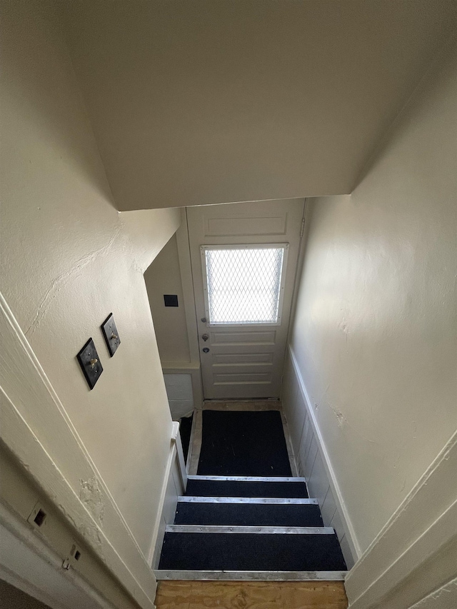 stairs featuring a wainscoted wall