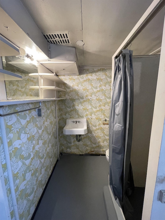 full bathroom with visible vents, toilet, a shower with shower curtain, wallpapered walls, and a sink
